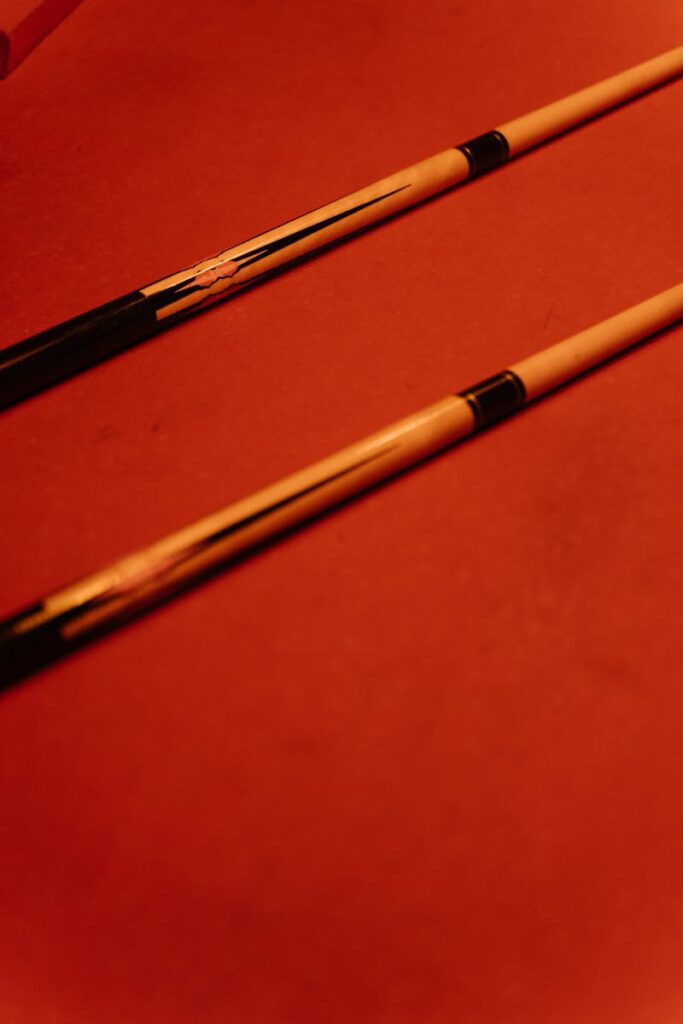 Close-Up Photo of Cue Sticks on Billard Table
