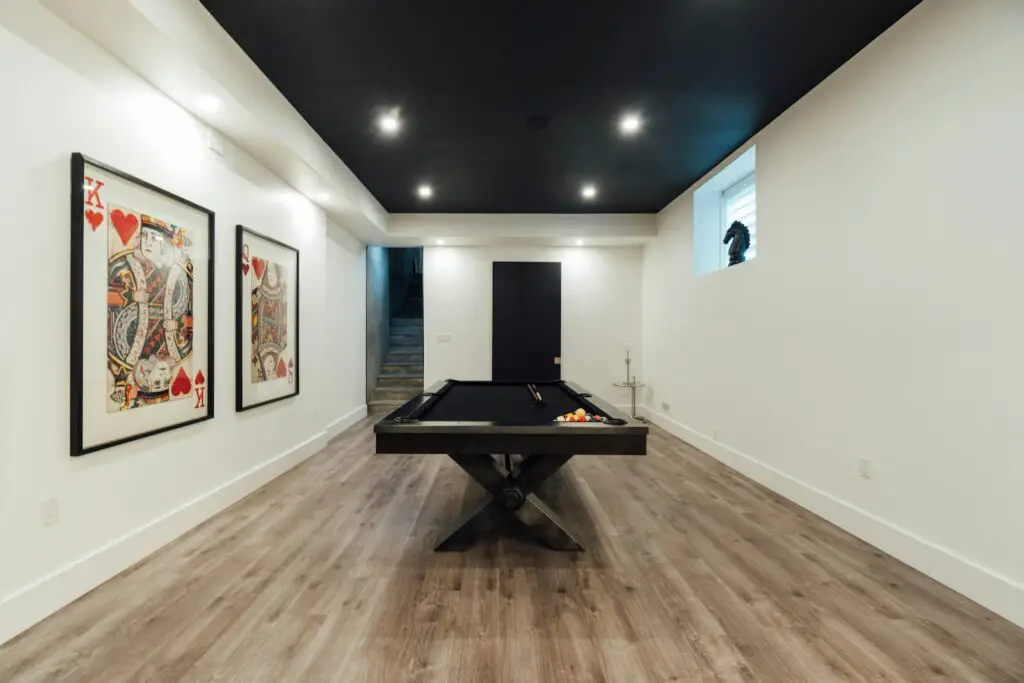 a room with a pool table and pictures on the wall